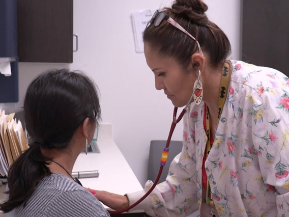 Nurse listens to patients heart with a stethoscope 