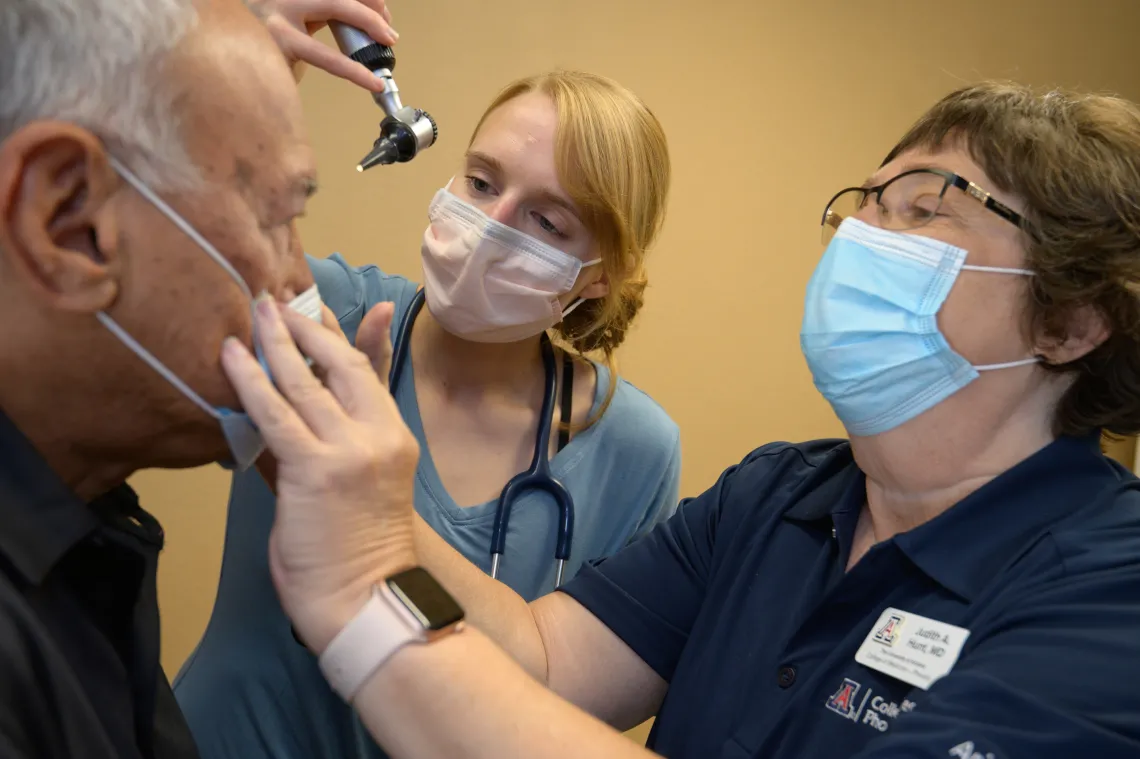 Dr Hunt examines a patient with a student