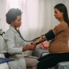 doctor taking blood pressure of pregnant woman